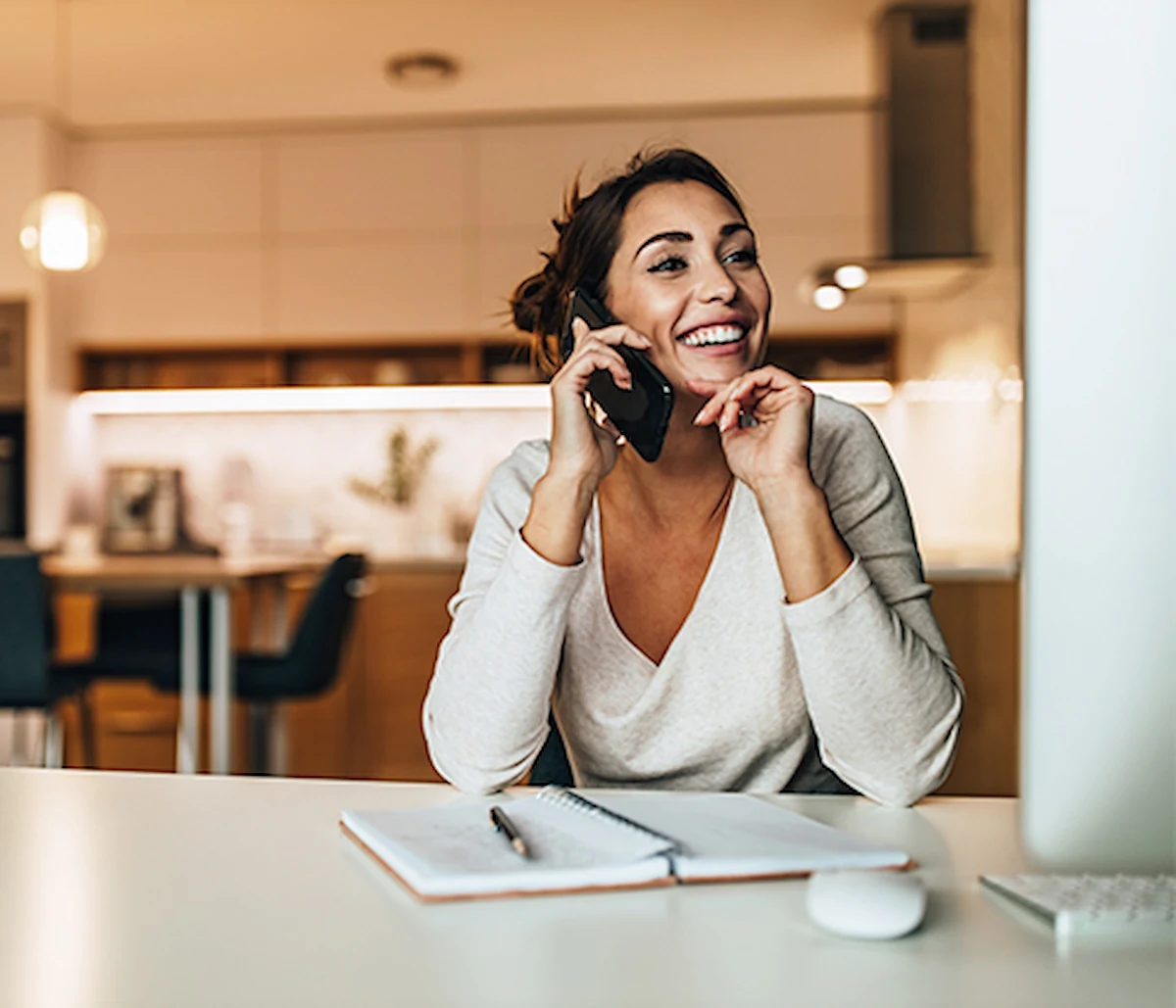 Happy customer in front of computer making phone call from home